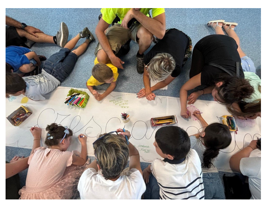 Mani grandi e mani piccole al lavoro per costruire il cartellone collettivo (2)